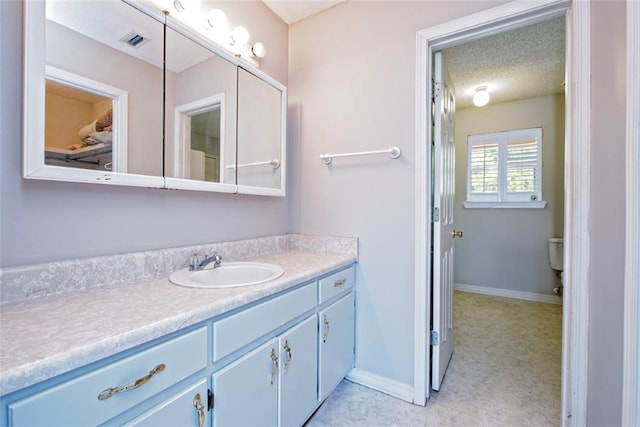 17180 Jim Platt Rd, Citronelle, AL 36522 - bathroom with vanity, a textured ceiling, baseboards, and toilet