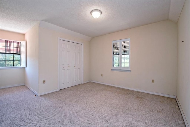 17180 Jim Platt Rd, Citronelle, AL 36522 - unfurnished bedroom featuring light colored carpet, multiple windows, a textured ceiling, a closet, and baseboards