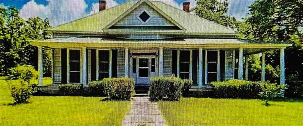 view of front of property featuring a chimney and a front yard