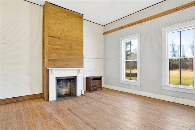 52780 State Highway 59, Stockton, AL 36579 - unfurnished living room featuring wood-type flooring, baseboards, a fireplace with flush hearth, and plenty of natural light