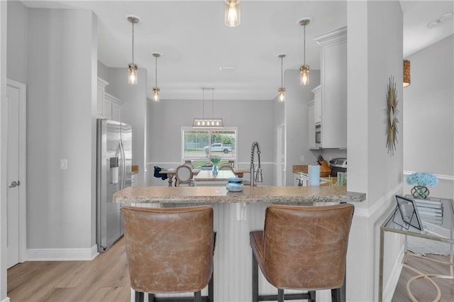 25504 Sunrise Ct, Loxley, AL 36551 - kitchen with stainless steel refrigerator with ice dispenser, light wood-style flooring, a peninsula, stove, and a kitchen bar