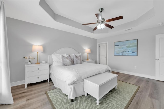 25504 Sunrise Ct, Loxley, AL 36551 - bedroom with a raised ceiling, light wood finished floors, baseboards, and a ceiling fan
