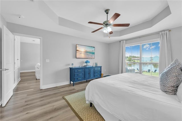 25504 Sunrise Ct, Loxley, AL 36551 - bedroom featuring a raised ceiling, light wood-style flooring, baseboards, and ceiling fan
