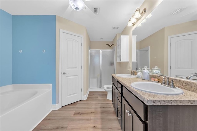 25504 Sunrise Ct, Loxley, AL 36551 - bathroom with a shower stall, wood finished floors, double vanity, a garden tub, and ceiling fan