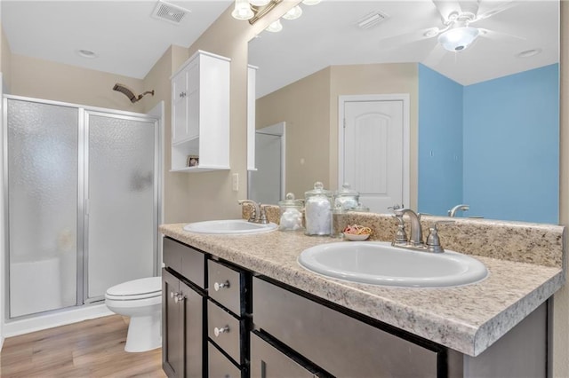 25504 Sunrise Ct, Loxley, AL 36551 - full bathroom with a stall shower, toilet, double vanity, wood finished floors, and ceiling fan