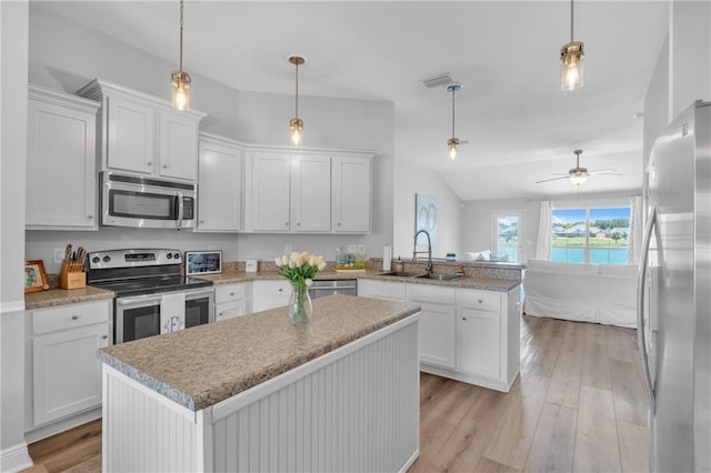 25504 Sunrise Ct, Loxley, AL 36551 - kitchen with appliances with stainless steel finishes, a sink, a peninsula, light wood-style floors, and white cabinets
