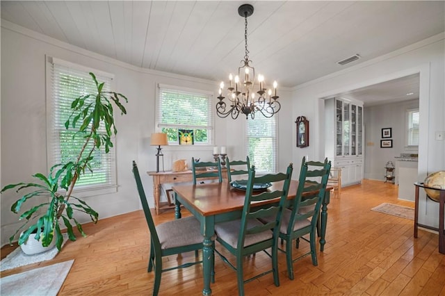 3009 Riverside Dr, Mobile, AL 36605 - dining area with a chandelier, light wood finished floors, and crown molding