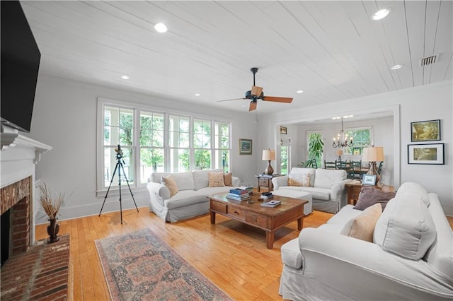 3009 Riverside Dr, Mobile, AL 36605 - living room featuring a fireplace, wood-type flooring, recessed lighting, ceiling fan, and a chandelier