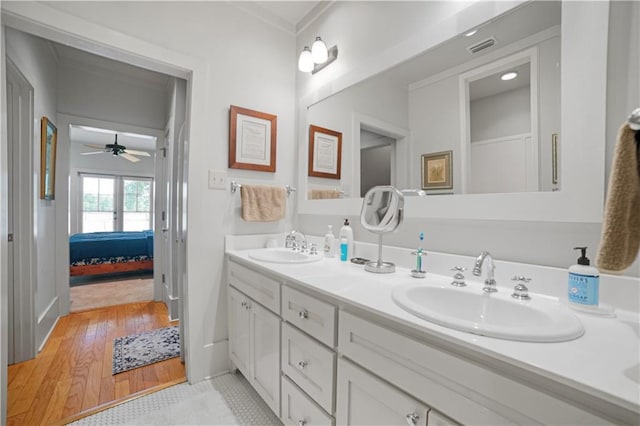 3009 Riverside Dr, Mobile, AL 36605 - ensuite bathroom featuring double vanity, wood finished floors, a ceiling fan, and crown molding