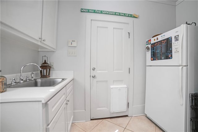 3009 Riverside Dr, Mobile, AL 36605 - kitchen featuring freestanding refrigerator, white cabinets, light countertops, and light tile patterned flooring