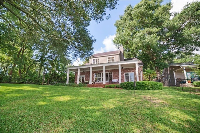 3009 Riverside Dr, Mobile, AL 36605 - rear view of property with covered porch, brick siding, a chimney, and a ceiling fan