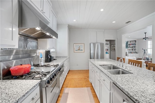 3009 Riverside Dr, Mobile, AL 36605 - kitchen featuring under cabinet range hood, appliances with stainless steel finishes, white cabinets, light wood-style floors, and recessed lighting