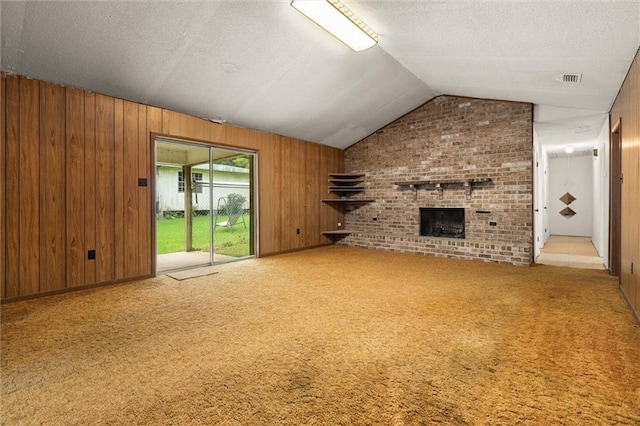 3163 Morgan Rd, Mobile, AL 36605 - unfurnished living room featuring wooden walls, a fireplace, lofted ceiling, carpet, and a textured ceiling