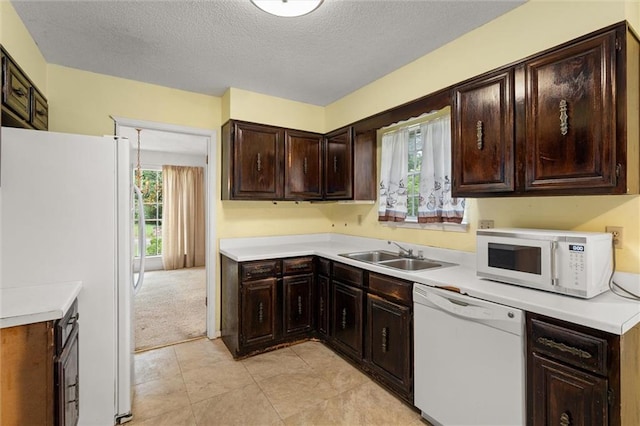 3163 Morgan Rd, Mobile, AL 36605 - kitchen with white appliances, a textured ceiling, dark brown cabinets, light countertops, and light tile patterned floors
