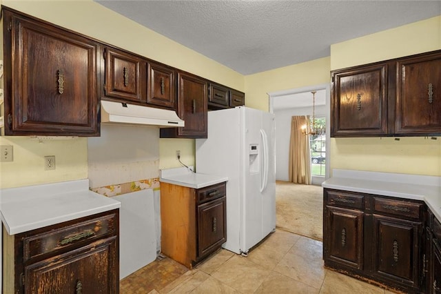 3163 Morgan Rd, Mobile, AL 36605 - kitchen with white fridge with ice dispenser, under cabinet range hood, dark brown cabinetry, light countertops, and a chandelier