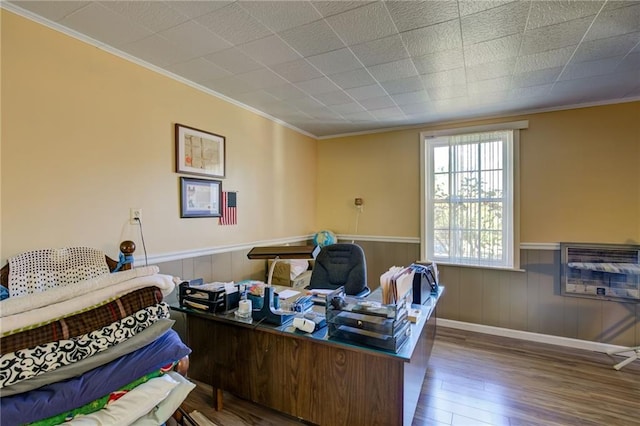 bedroom featuring wooden walls, dark hardwood / wood-style flooring, heating unit, and crown molding