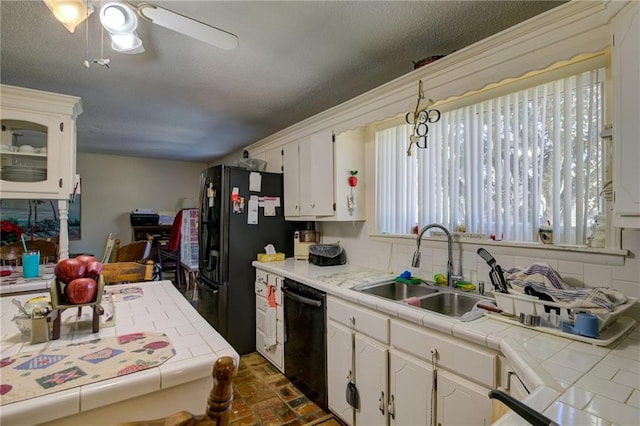 kitchen featuring black appliances, white cabinets, sink, ceiling fan, and tile counters