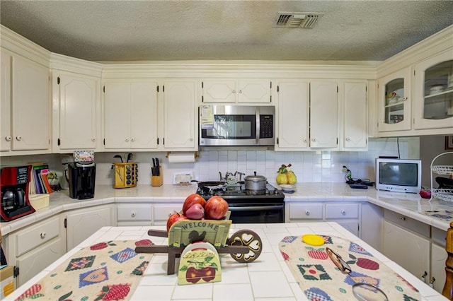 kitchen featuring tile countertops and black range with electric stovetop