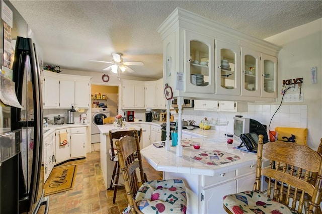 kitchen with white cabinetry, ceiling fan, stainless steel appliances, tasteful backsplash, and washer / clothes dryer