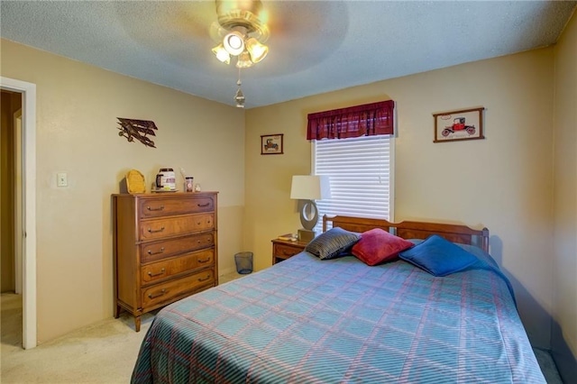 bedroom with ceiling fan, light carpet, and a textured ceiling