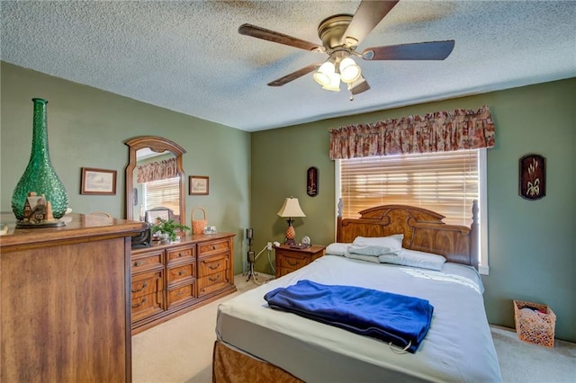 carpeted bedroom featuring a textured ceiling and ceiling fan