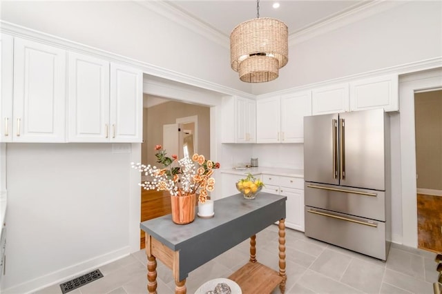 kitchen with decorative light fixtures, white cabinetry, high end refrigerator, light tile patterned floors, and crown molding