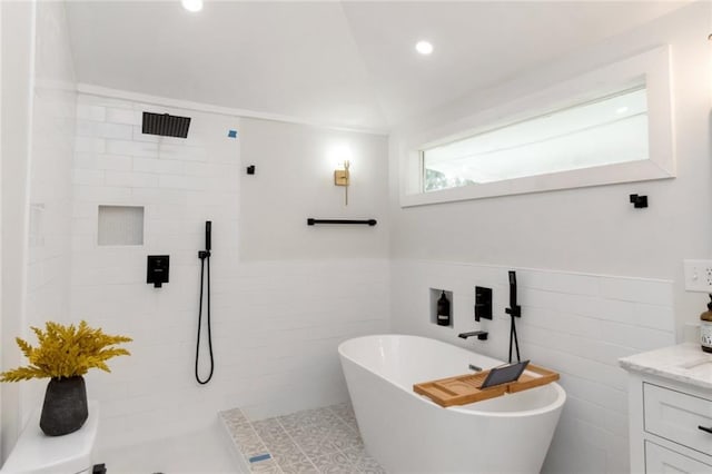 bathroom featuring vanity, plus walk in shower, and tile walls