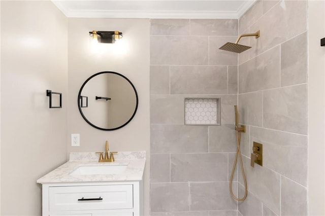 bathroom with crown molding, vanity, and a tile shower