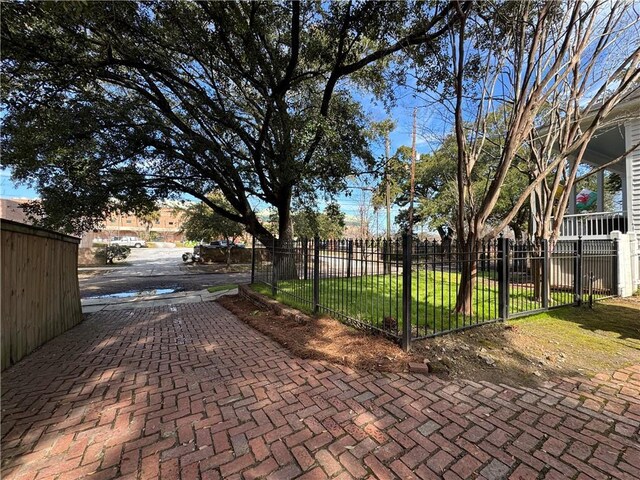 view of gate with a lawn