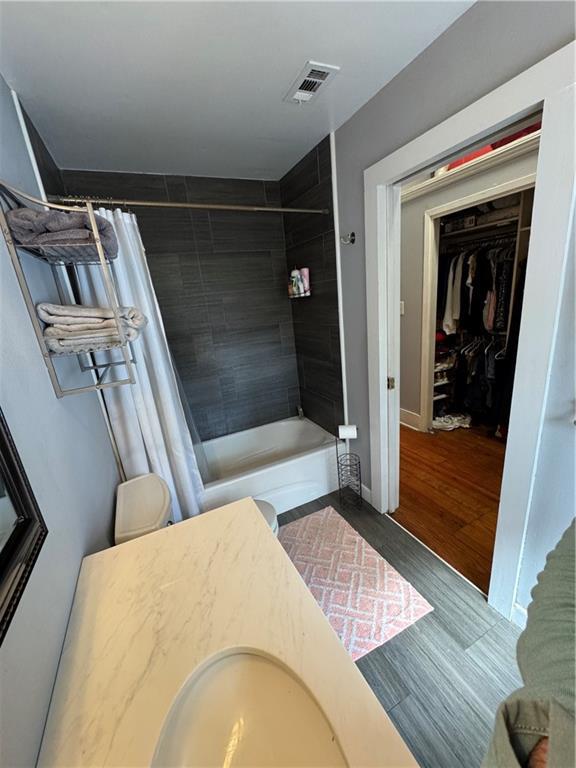 bathroom with vanity, hardwood / wood-style floors, and shower / bath combo with shower curtain