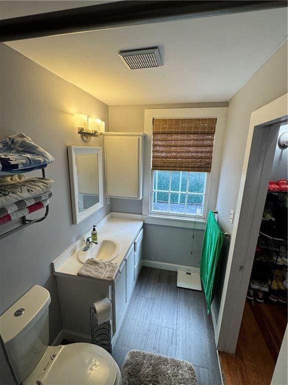 bathroom featuring vanity, wood-type flooring, and toilet