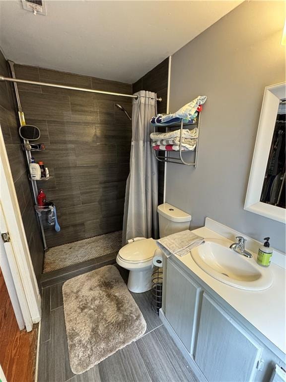 bathroom with a shower with curtain, vanity, and toilet