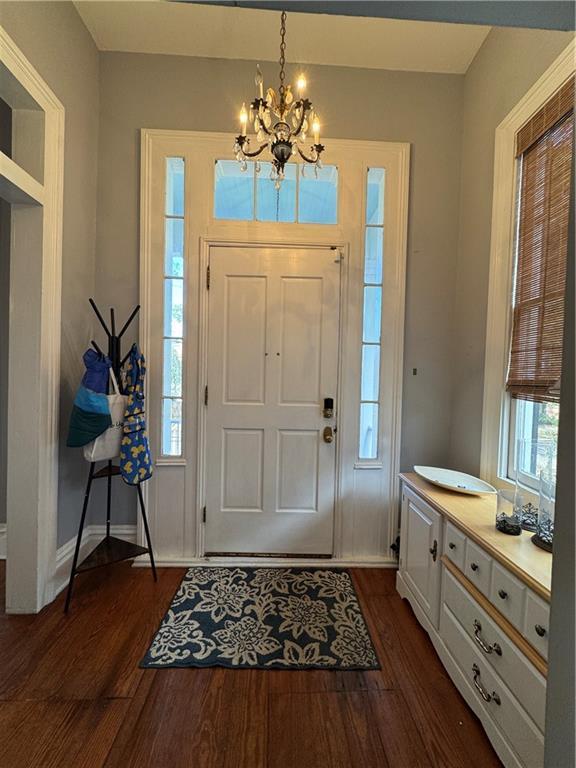 entryway featuring dark hardwood / wood-style flooring and a chandelier