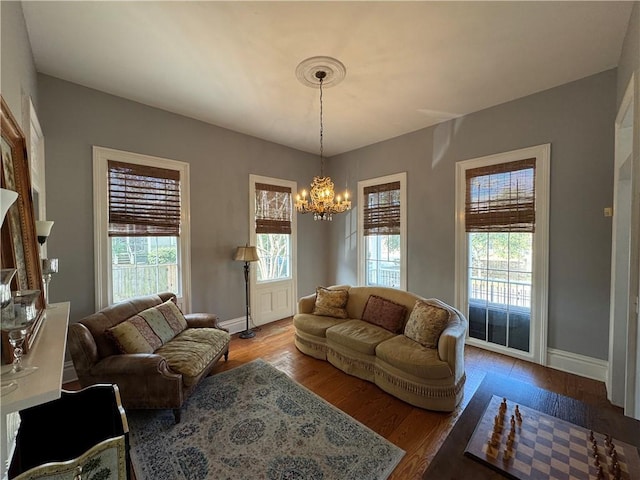 living room featuring a notable chandelier, wood-type flooring, and a wealth of natural light