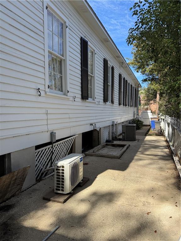 view of side of home with ac unit, central AC, and a patio area