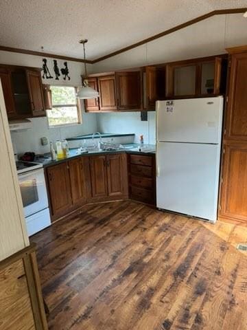 kitchen featuring lofted ceiling, a textured ceiling, dark hardwood / wood-style floors, pendant lighting, and white appliances