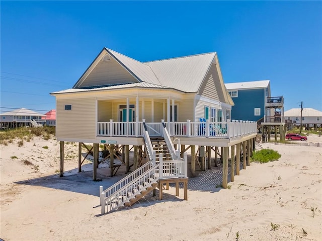 106 Serigny Ct, Dauphin Island, AL 36528 - view of front facade featuring covered porch, a carport, stairway, and metal roof