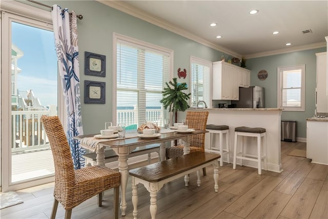 106 Serigny Ct, Dauphin Island, AL 36528 - dining room featuring crown molding, light wood finished floors, recessed lighting, and baseboards