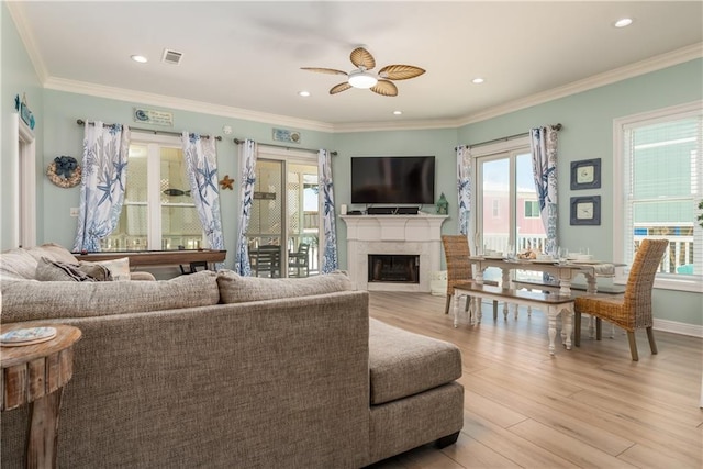106 Serigny Ct, Dauphin Island, AL 36528 - living room with healthy amount of natural light, a ceiling fan, a high end fireplace, light wood-style floors, and crown molding