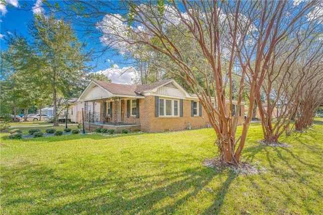 view of front of property with brick siding, crawl space, covered porch, and a front yard