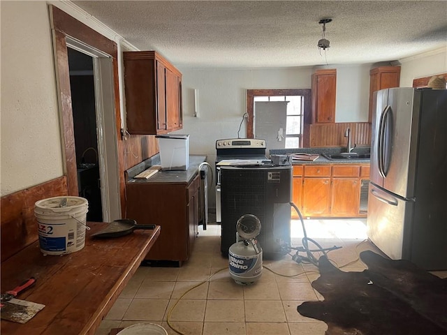 kitchen featuring sink, light tile patterned flooring, a textured ceiling, and appliances with stainless steel finishes