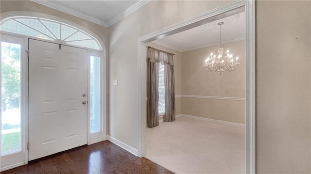 foyer entrance with ornamental molding, dark hardwood / wood-style flooring, a wealth of natural light, and a notable chandelier