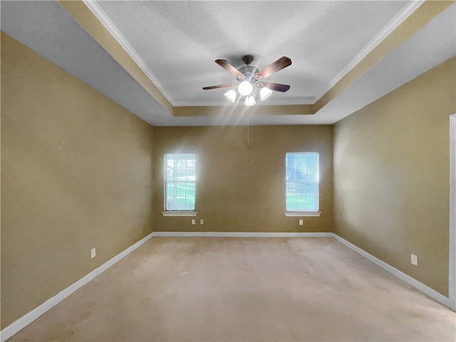 empty room featuring ceiling fan, a healthy amount of sunlight, a raised ceiling, and a textured ceiling