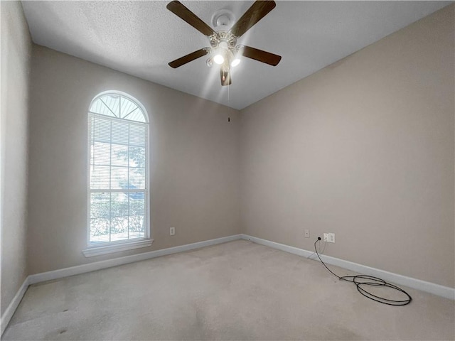 carpeted spare room with ceiling fan and a textured ceiling