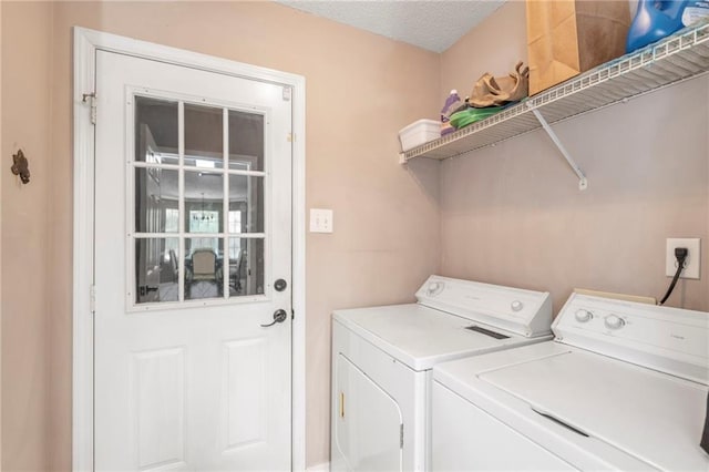 clothes washing area with independent washer and dryer and a textured ceiling