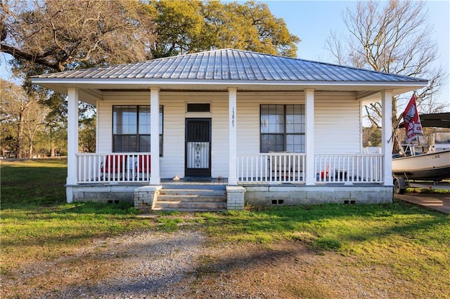 bungalow-style home with crawl space, metal roof, covered porch, and a front lawn