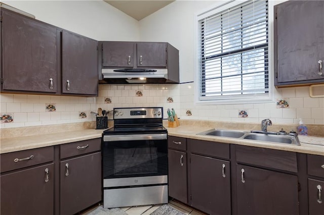 kitchen featuring stainless steel electric stove, a sink, light countertops, under cabinet range hood, and backsplash