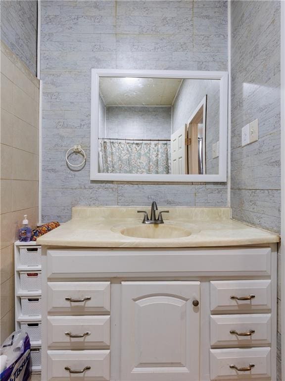 full bath with tile walls and vanity