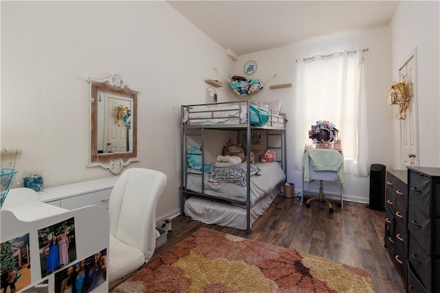 bedroom featuring baseboards and dark wood-style flooring