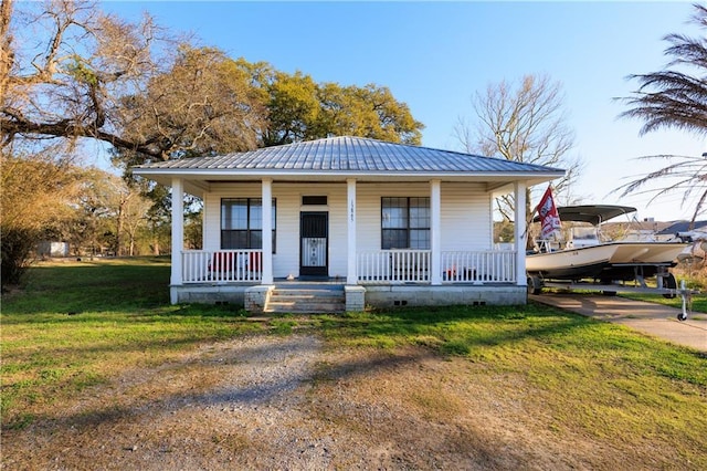 bungalow with a porch, metal roof, driveway, and a front yard